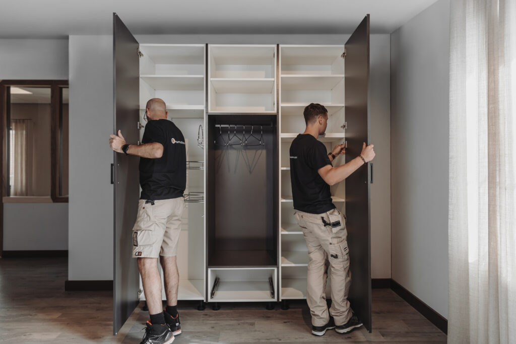 twee mannen monteren een bijkeukenkast met deuren.